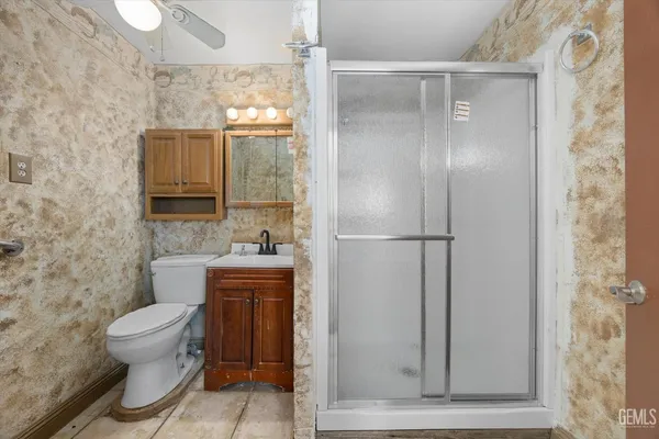 a bathroom with a granite countertop toilet a sink and a mirror