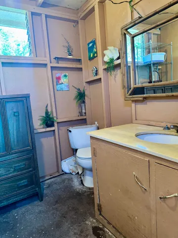 a bathroom with a toilet sink and mirror