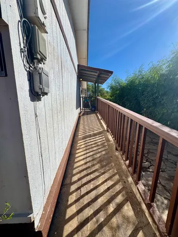 a view of balcony with wooden floor and fence