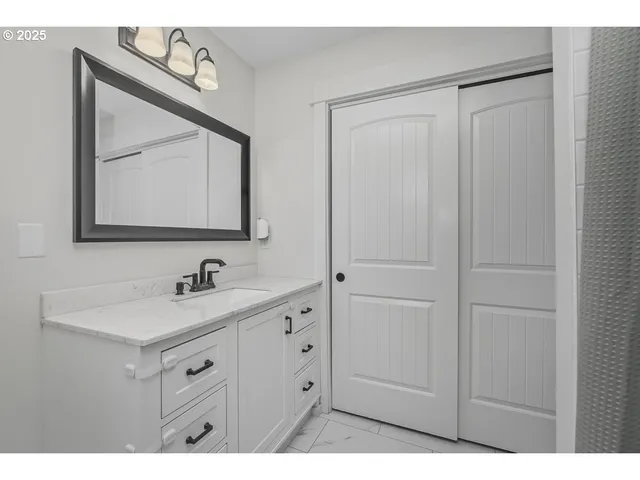 a bathroom with a sink vanity and a mirror