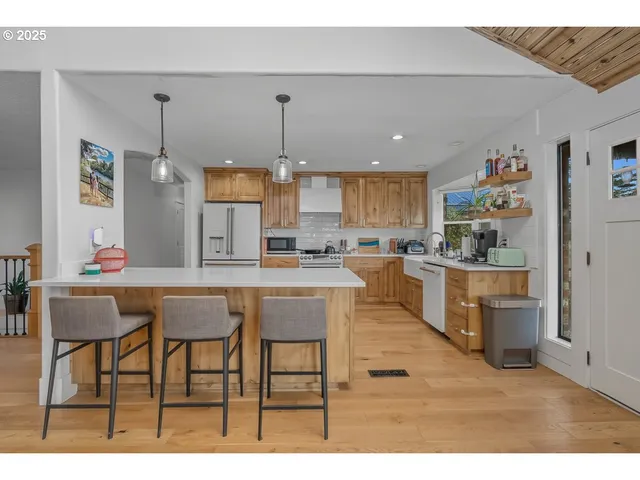 a kitchen with granite countertop a table chairs stove and cabinets