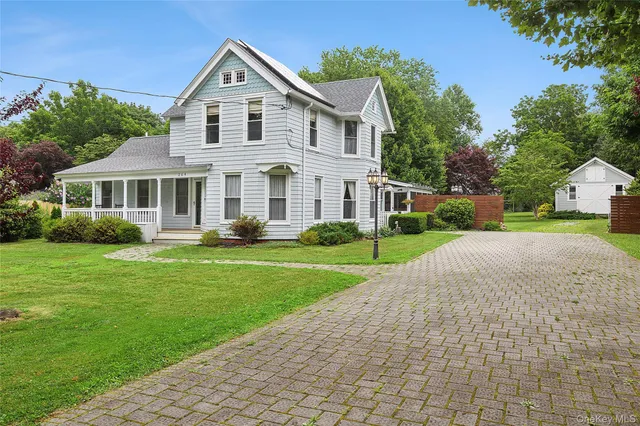 a front view of a house with a yard and potted plants