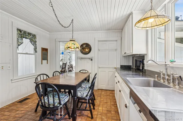a view of a dining room and kitchen with a table and chairs