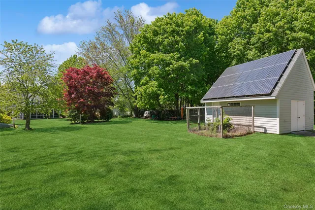 an aerial view of residential houses with outdoor space and trees