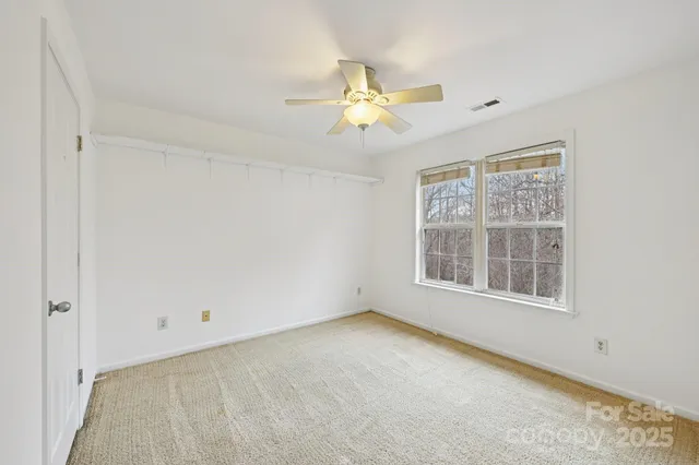 an empty room with a window and a fan