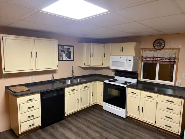 a kitchen with granite countertop white cabinets and black appliances