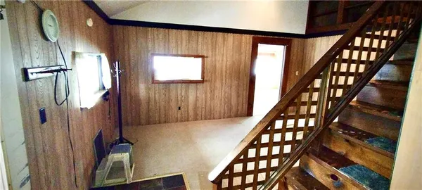 a view of staircase with wooden floor and a large window