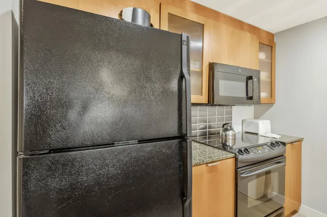 a kitchen with granite countertop a sink a counter top space and living room view