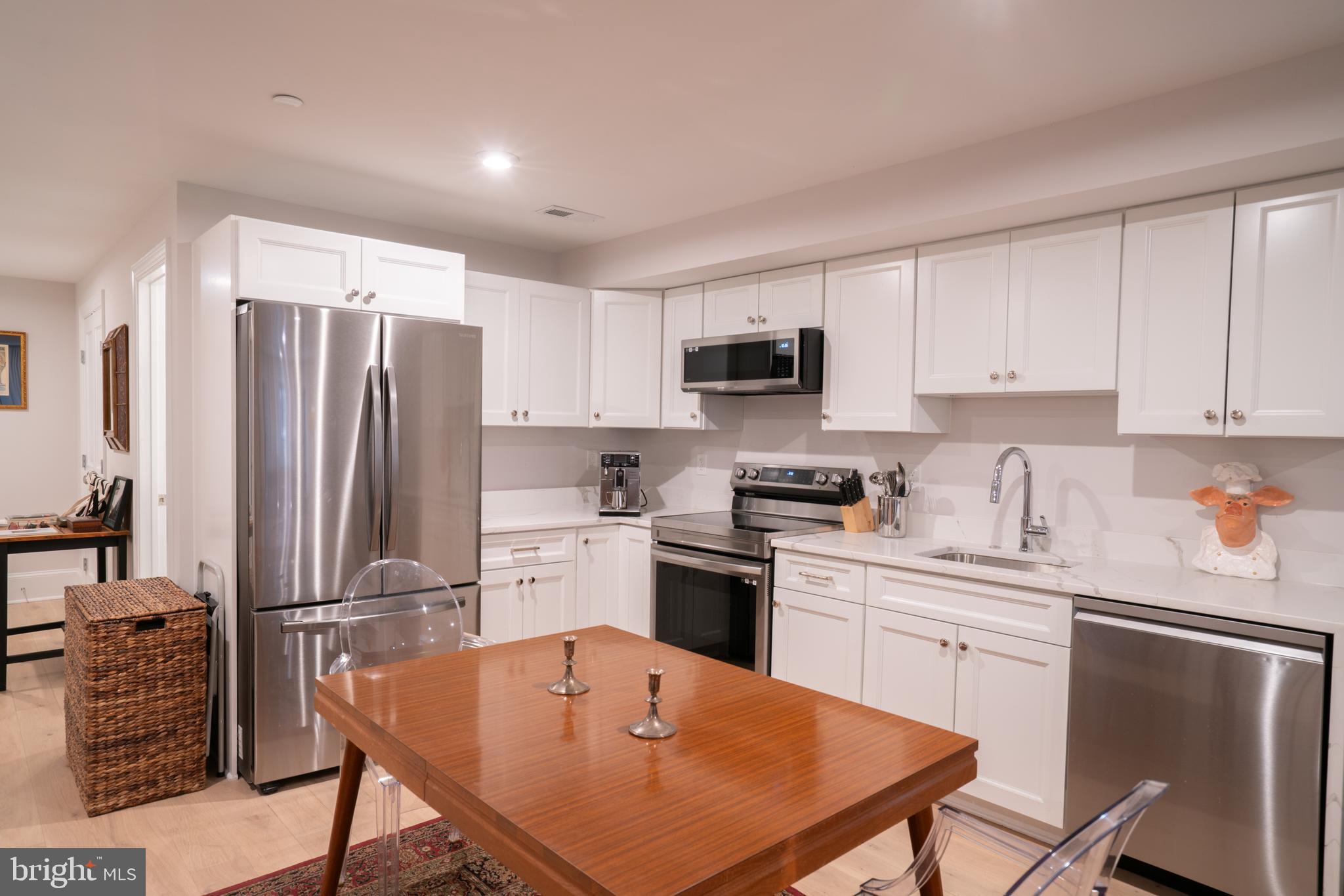 911 M Street Northwest Washington, DC 20001 - Photo 23 of 31 a kitchen with stainless steel appliances a stove a sink dishwasher a refrigerator with white cabinets and wooden floor