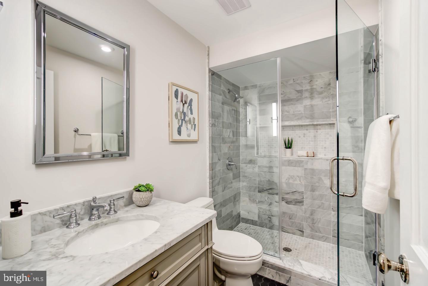 911 M Street Northwest Washington, DC 20001 - Photo 24 of 31 a bathroom with a granite countertop sink toilet a mirror and shower