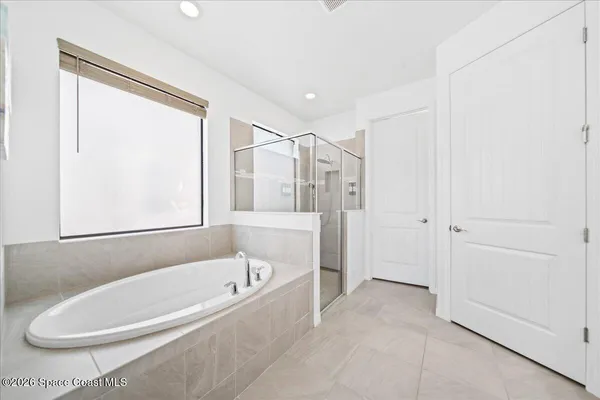 a white bath tub sitting next to a shower