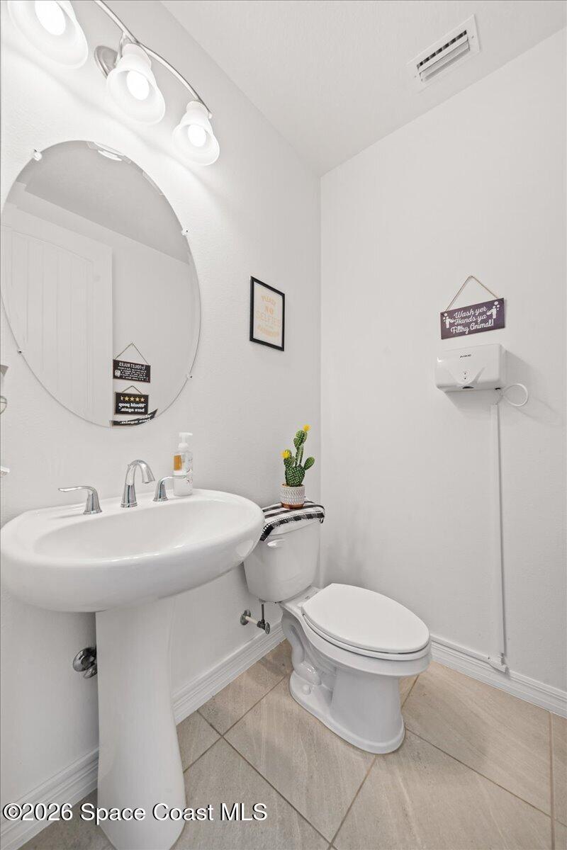 3235 Hummingbird Way Melbourne, FL 32940 - Photo 19 of 31 a bathroom with a sink toilet and mirror