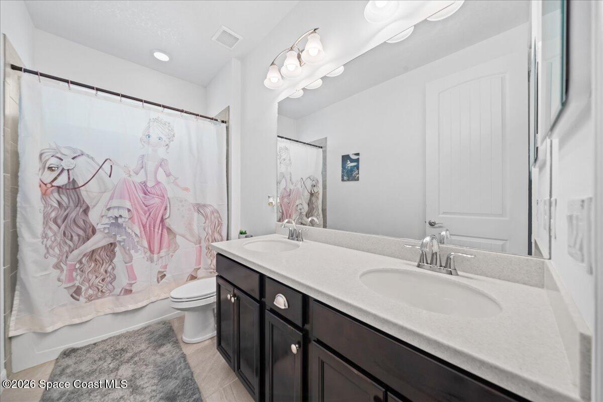 3235 Hummingbird Way Melbourne, FL 32940 - Photo 20 of 31 a bathroom with a granite countertop sink a large mirror and shower