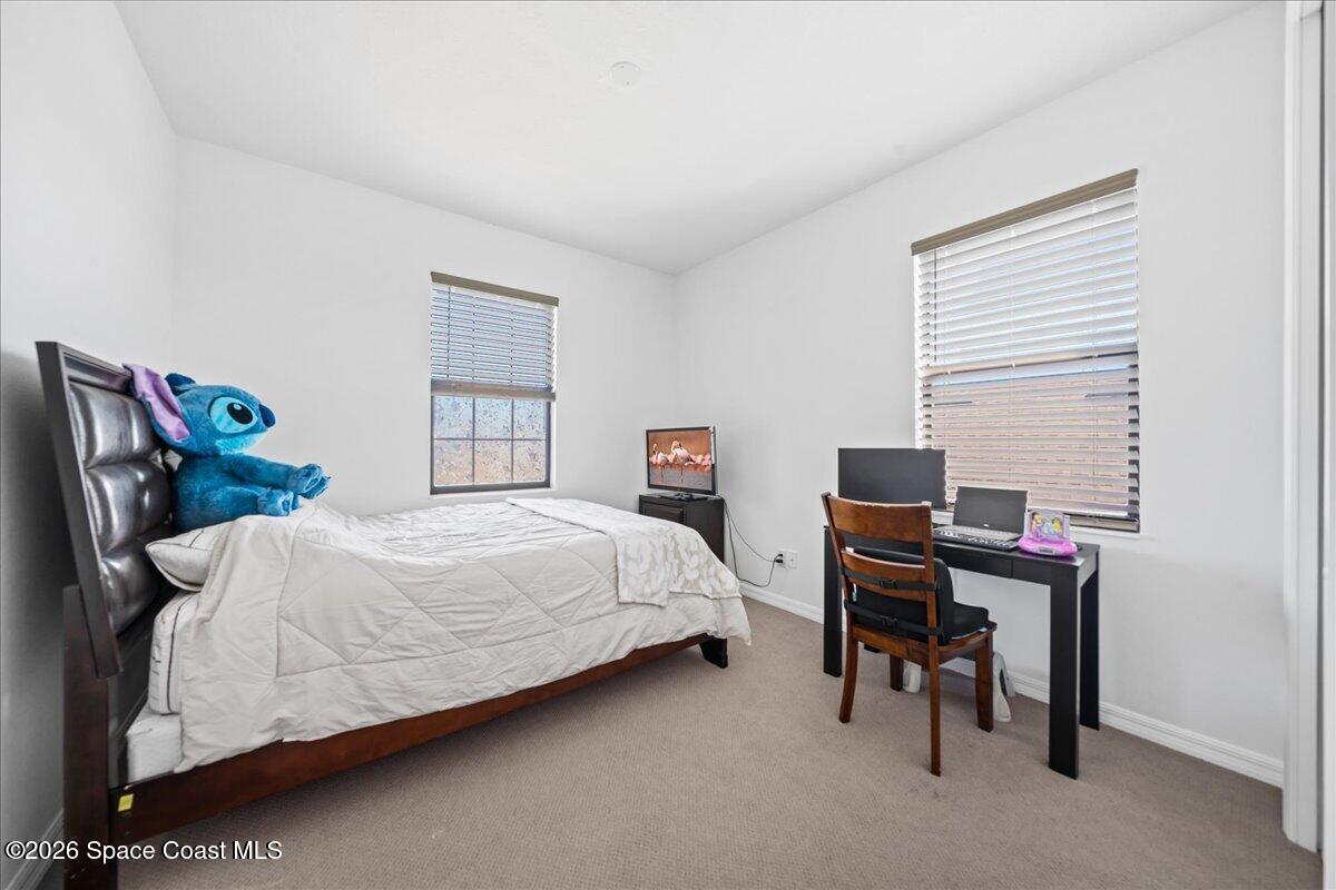 3235 Hummingbird Way Melbourne, FL 32940 - Photo 22 of 31 a bedroom with a bed and a desk