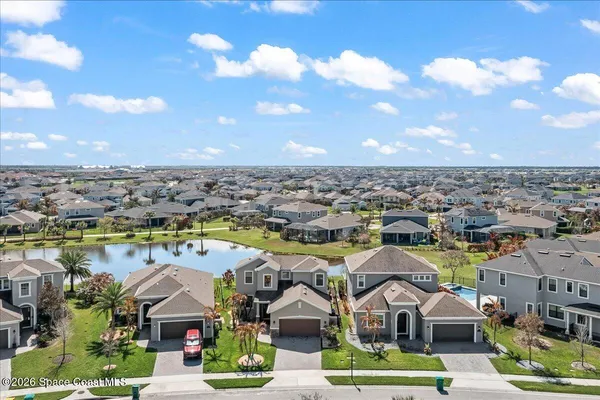 an aerial view of residential houses with outdoor space and lake view