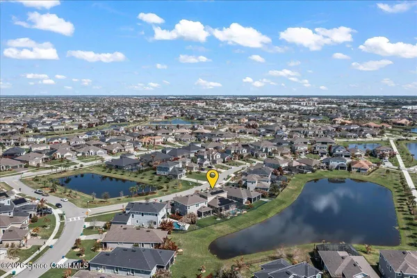 an aerial view of a city with lots of residential buildings and ocean view in back