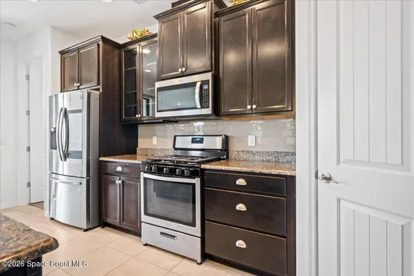 a kitchen with stainless steel appliances granite countertop a refrigerator stove and microwave