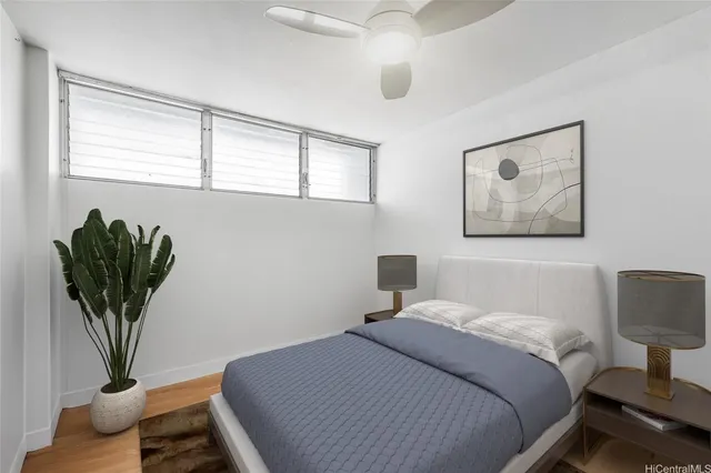 a bedroom with a bed and a potted plant