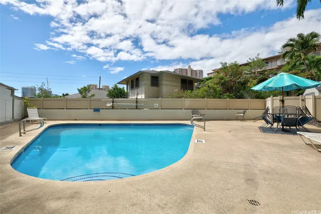 a view of a swimming pool with a yard and sitting area