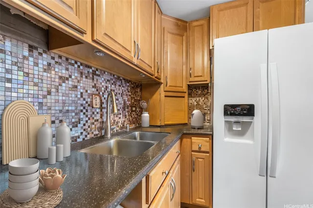 a kitchen with stainless steel appliances granite countertop a refrigerator and a stove