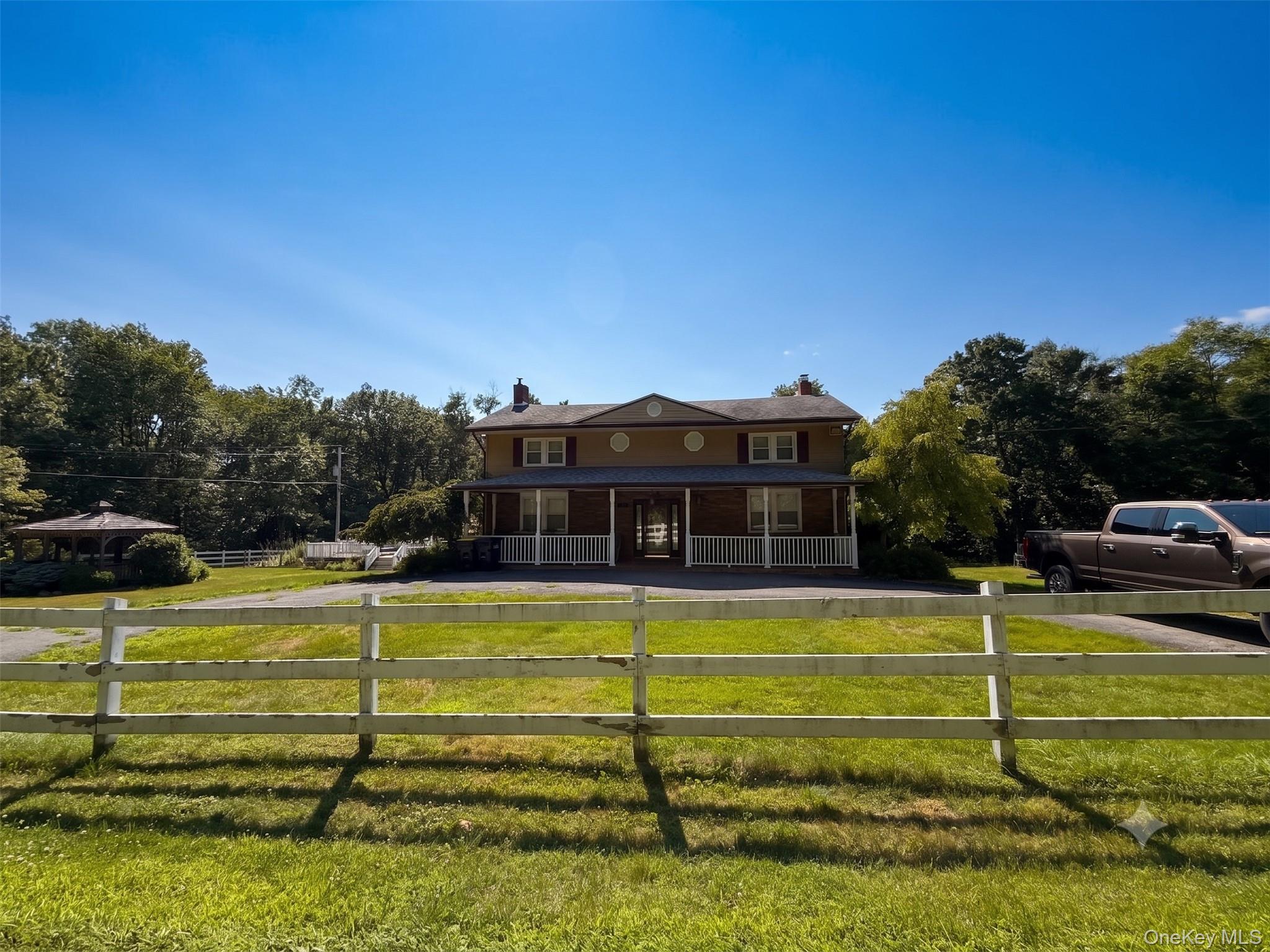 180 Harris Road Harris, NY 12742 - Photo 2 of 34 Two-story property featuring a covered porch with white railings, a circular drive, and a detached gazebo