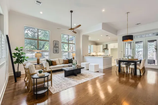 a living room with furniture kitchen view and a wooden floor