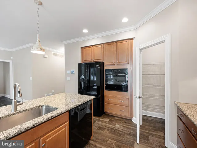 a kitchen with granite countertop a refrigerator and a sink