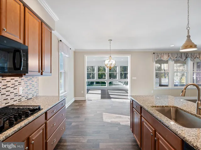 a kitchen with stainless steel appliances granite countertop a sink and a stove
