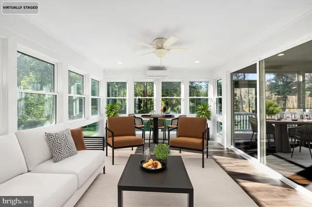 a living room with furniture and floor to ceiling windows