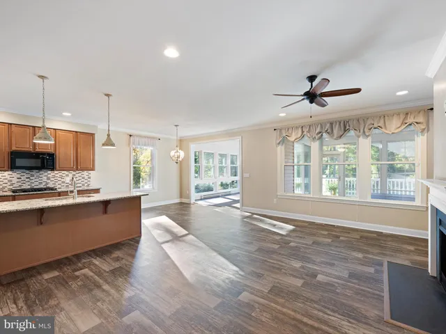 a large kitchen with kitchen island granite countertop a large window and stainless steel appliances