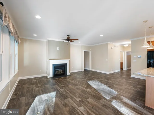 a view of a livingroom with a fireplace and chandelier fan