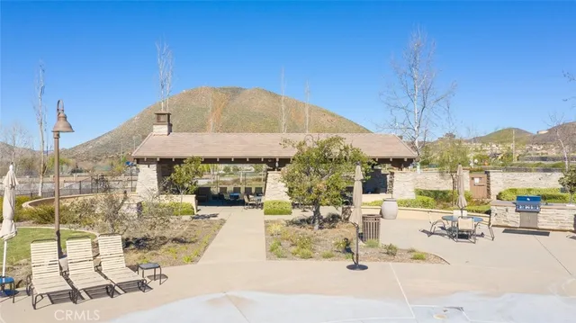 a patio with water view fountain with a table and chairs under an umbrella
