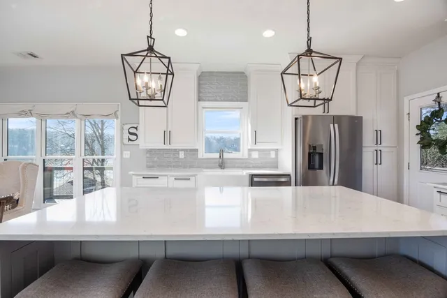 a bathroom with double vanity sinks a large mirror and a bathtub
