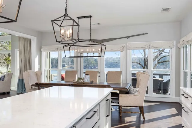 a living room with furniture a ceiling fan a flat screen tv and a large window
