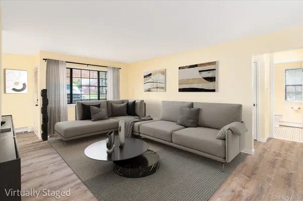 a living room with furniture a large window and a wooden floor