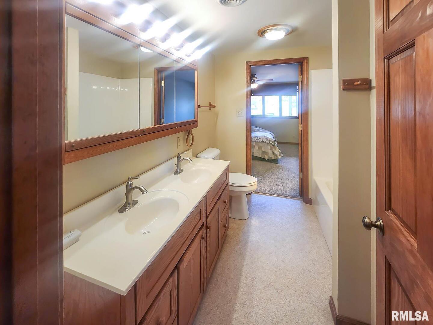 2878 Sunfield Road Du Quoin, IL 62832 - Photo 43 of 47 a en suite bathroom with a double vanity sink a mirror and a shower