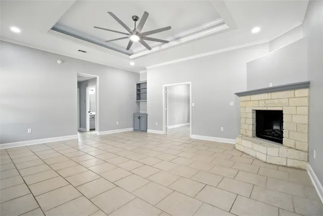an empty room with fan and a fireplace
