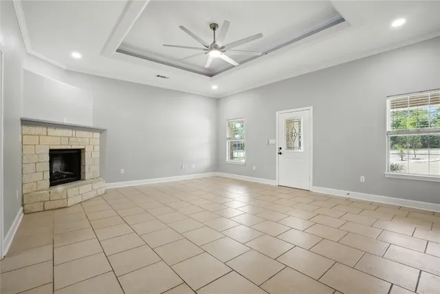 an empty room with windows and ceiling fan