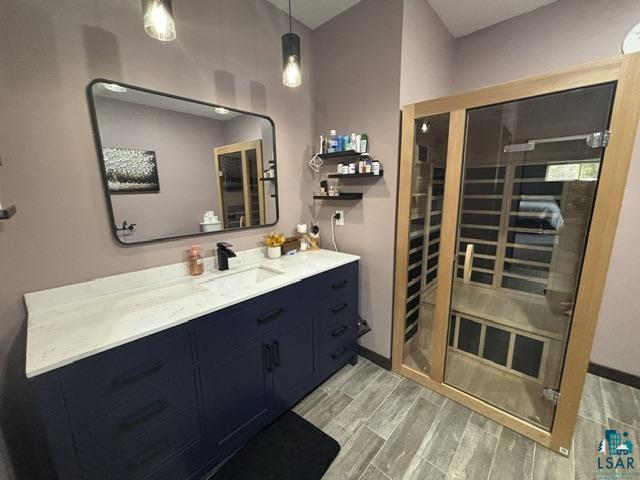 3454 Anderson Road Hibbing, MN 55746 - Photo 10 of 31 Wood-finish flooring provides a durable foundation for this space, featuring a vanity with a white countertop and a dark blue base