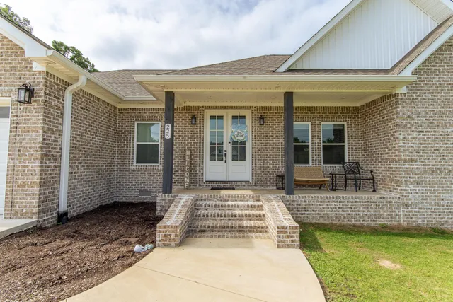 a view of a white building with swimming pool in front of it