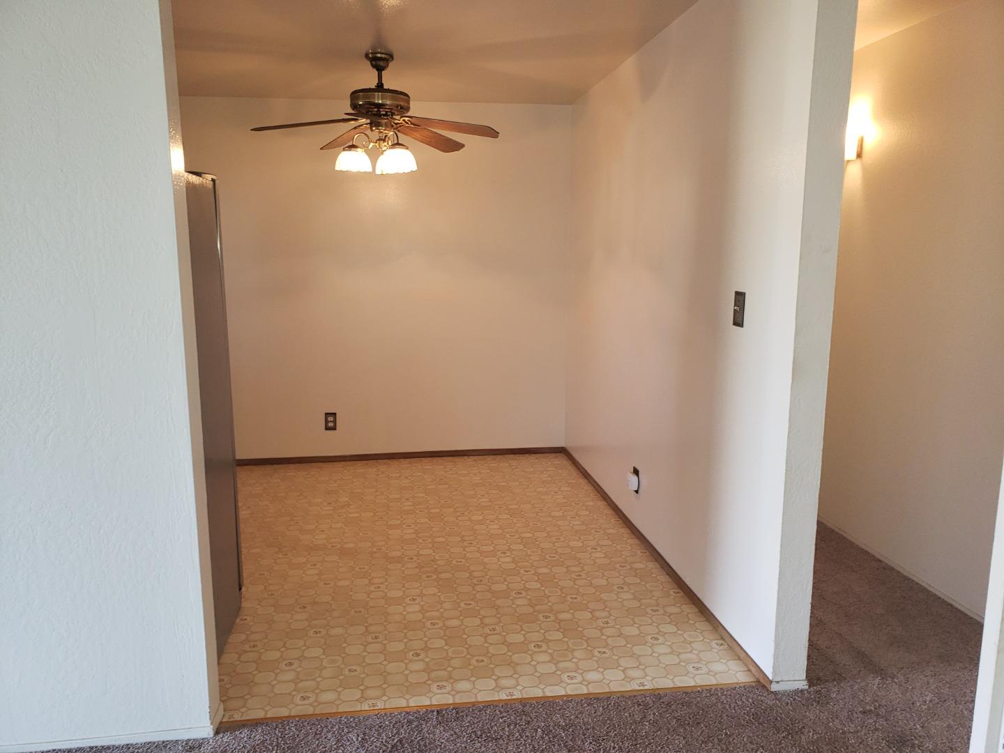 562 Leslie Drive Salinas, CA 93906 - Photo 7 of 21 an empty room with a chandelier fan and a window