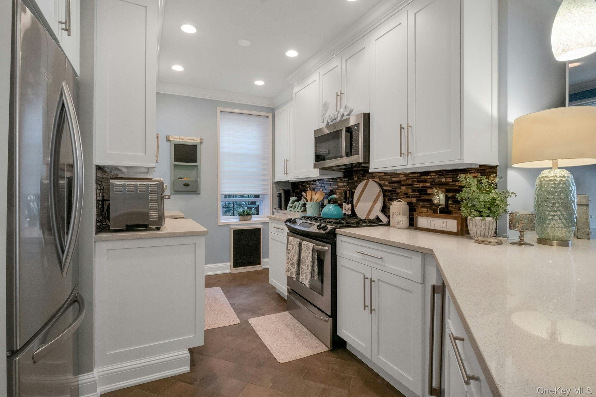 101 Old Mamaroneck Road, Unit 2C5 White Plains, NY 10605 - Photo 11 of 35 a kitchen with cabinets appliances a sink and a counter top space