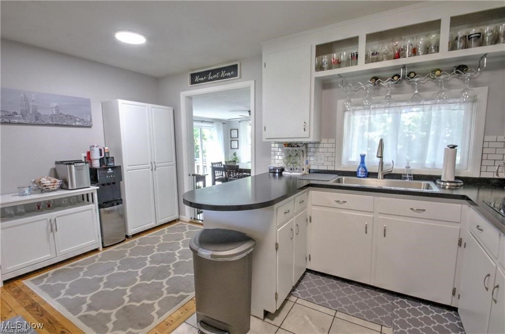 7368 Hopkins Road Mentor, OH 44060 - Photo 10 of 37 Kitchen with a peninsula, decorative backsplash, white cabinets, and a sink