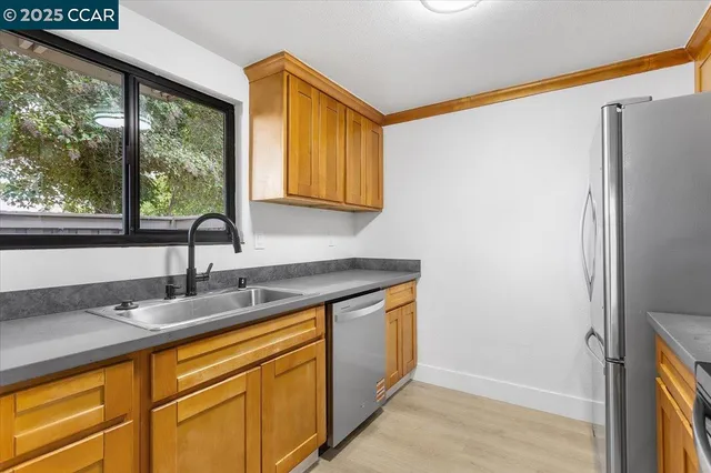 a kitchen with stainless steel appliances granite countertop a refrigerator and a sink