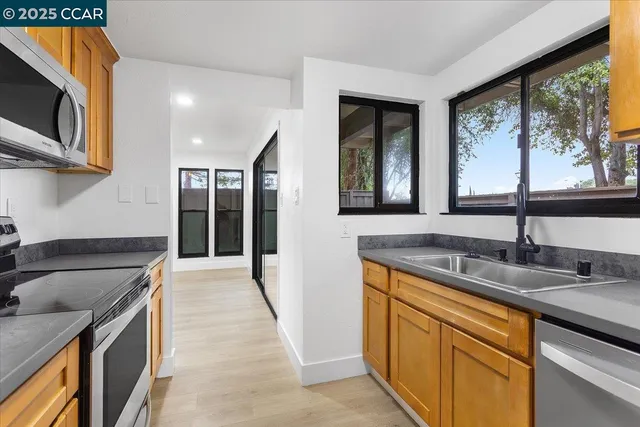 a kitchen with granite countertop stainless steel appliances a stove sink and microwave