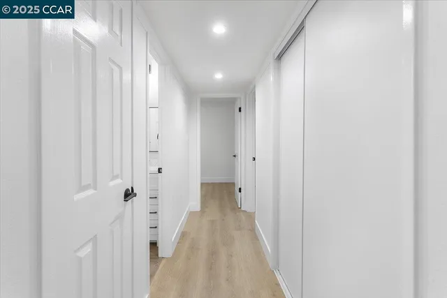 a view of a hallway with wooden floor and staircase