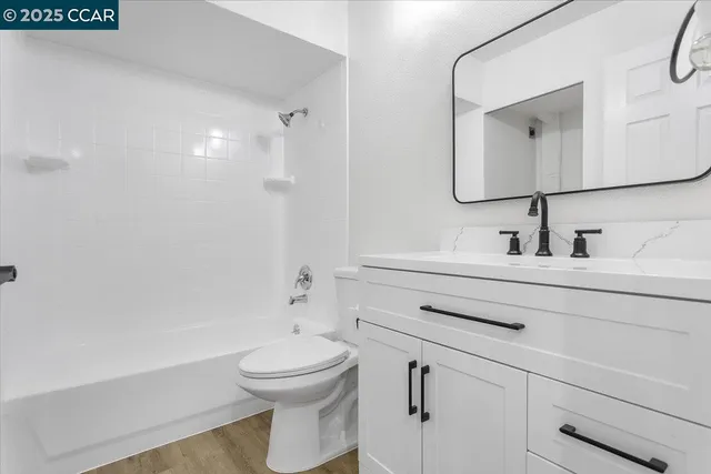 a bathroom with a toilet a sink a mirror and vanity
