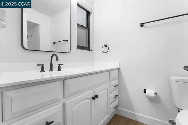 a bathroom with a sink and mirror with toilet