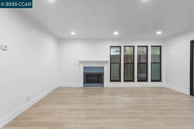 a view of an empty room with a fireplace and a window