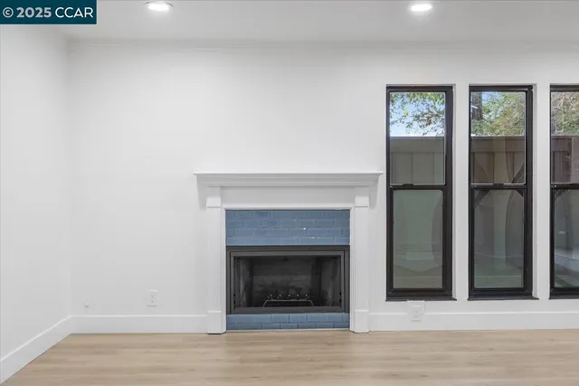 an empty room with windows and a fireplace